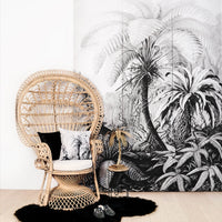 Exotic jungle wall mural in boho living room interior with peacock chair and tropical cushions