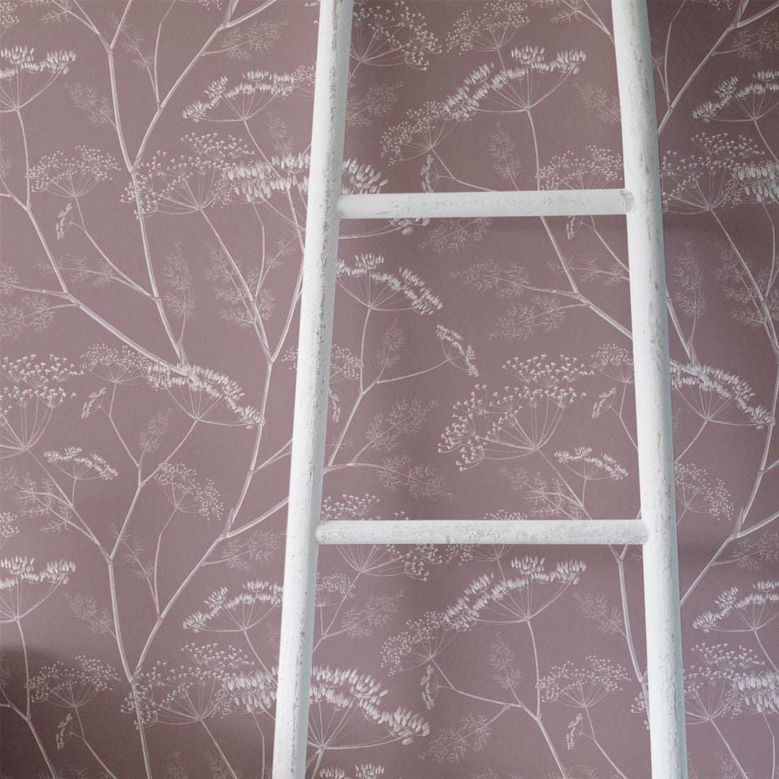 Vintage shabby chic style girl's room interior with dusty pink floral wallpaper