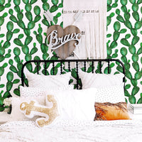 Watercolor cactus removable wallpaper in eclectic boho girl's bedroom with black farmhouse style bed, woven wall hanging and texas inspired interior decor